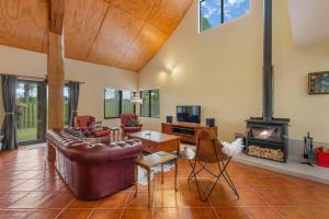 a living room with a couch and a fireplace at Modern Barn Style - Taupo Holiday Home in Kinloch