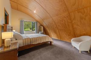 a bedroom with a bed and a desk and a chair at Modern Barn Style - Taupo Holiday Home in Kinloch