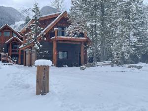 uma cabana com neve em frente em Ski-In Chalet: Private Hot tub, Bonus Bunk House em Fernie