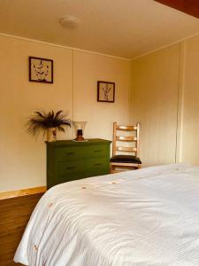 sypialnia z białym łóżkiem i zieloną komodą w obiekcie Ski-In Chalet: Private Hot tub, Bonus Bunk House w mieście Fernie