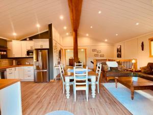 a kitchen and living room with a table and chairs at Ski-In Chalet: Private Hot tub, Bonus Bunk House in Fernie