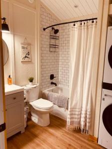 uma casa de banho com um WC, uma banheira e um lavatório. em Ski-In Chalet: Private Hot tub, Bonus Bunk House em Fernie