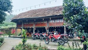 un grupo de motocicletas estacionadas frente a un edificio en Giang Tien Homestay-VuLinh Farmstay ThacBa en Yên Bình