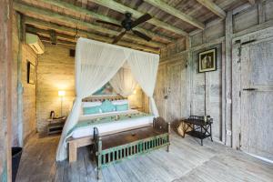 a bedroom with a bed with a canopy at Villa Sungai Laut in Canggu
