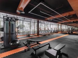 a gym with a row of treadmills and weights at Nysa Bangkok Sukhumvit 11 by Kingston Hotels in Bangkok