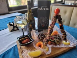 un plato de comida en una mesa con una botella de vino en Хотел “Райски кът” en Cheresha
