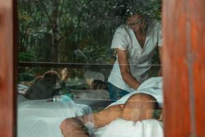Hotel Isabella Tayrona في لوس نارانخوس: امرأة تقف بجانب سرير مع مريض
