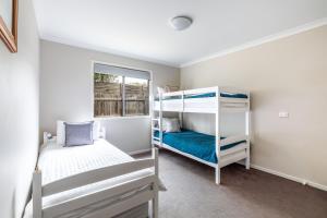 a bedroom with two bunk beds and a window at Oakdean Resort- Pool, Spa, Beach, Sleep 10 in Ocean Grove +47 photos