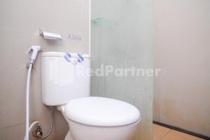 - une salle de bains avec des toilettes blanches dans une cabine dans l'établissement Rumah Daun Timoho Yogyakarta RedPartner, à Yogyakarta