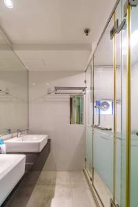 uma casa de banho branca com um lavatório e um chuveiro em Seaview Maritime Suite Pool 2Carparks em Jelutong
