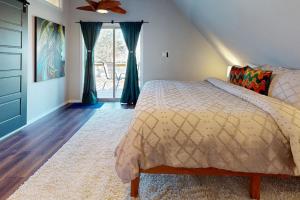 1 dormitorio con 1 cama y ventilador de techo en The Blue Beaver Cottage, en Rogers