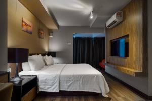 um quarto de hotel com uma cama e uma televisão em Seaview Maritime Suite Pool 2Carparks em Jelutong