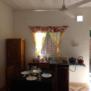 a kitchen with a table with plates and a window at Hospedaje Espindoliky in Bella Vista