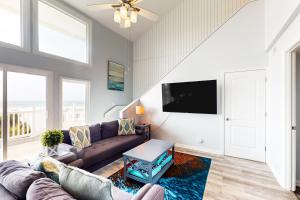 a living room with a couch and a tv at Oceanfront Oasis in Emerald Isle
