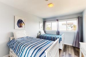 two twin beds in a room with a window at Oceanfront Oasis in Emerald Isle