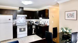 eine Küche mit weißen Geräten und schwarzen Schränken in der Unterkunft Beautiful Home in Burnaby. (Lyn's Residence) in Burnaby