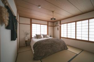 a bedroom with a bed and two windows at Shofusha Lodge Madarao Tangram in Madarao Kogen +32 photos