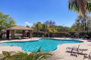 a large swimming pool with a gazebo and chairs at Garden Breeze in Gilbert