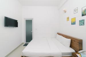a bedroom with a bed and a tv on a wall at Mat Troi Vang Dalat Hotel in Da Lat