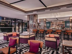 a bar at a hotel with purple chairs and tables at Nysa Hotel Bangkok Sukhumvit 11 in Bangkok