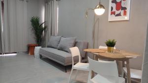 ein Wohnzimmer mit Sofa, Tisch und Stühlen in der Unterkunft WUER Expiatorio in León