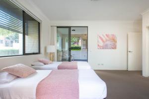 two beds in a bedroom with a window at Spacious Two-Bedroom Apartment near Hospital in Sydney