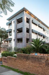 un immeuble d'appartements avec un mur en briques devant lui dans l'établissement Spacious Two-Bedroom Apartment near Hospital, à Sydney