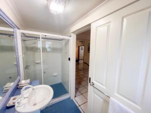 une salle de bain avec un lavabo et une douche en verre dans l'établissement La Riviera One - Coastal Lifestyle - Three Bedroom, à South Mission Beach