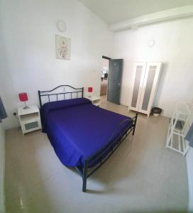 a bedroom with a bed with a purple blanket at Home From Home in Nugegoda