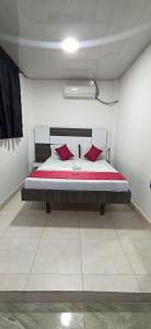 une chambre avec un lit avec des oreillers rouges dessus dans l'établissement Hotel Sol Del LLano, à Villavicencio