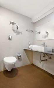a bathroom with a toilet and a sink and a mirror at Monarch Brigade Road in Bangalore