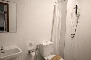 a white bathroom with a toilet and a sink at Y House Patong in Patong Beach