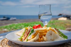 a sandwich and french fries and a glass of wine at Ocean Paradise Bali in Buleleng