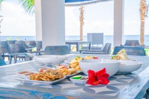 a table with bowls and plates of food on it at Ocean Paradise Bali in Pabean Buleleng