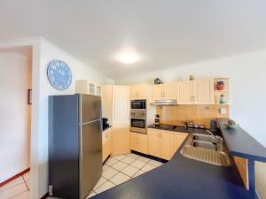 une cuisine avec un réfrigérateur et des armoires en acier inoxydable dans l'établissement La Riviera One Coastal Life Style One Bedroom, à South Mission Beach 9 autres photos