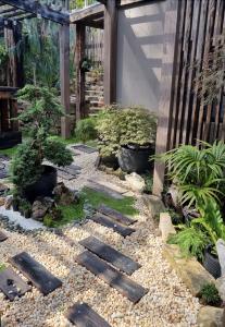 einen Garten mit Holztreppen und Pflanzen und einem Zaun in der Unterkunft Kashikiri- Adelaide Hills Private Japanese Bath Retreat- pre-finished special in Crafers