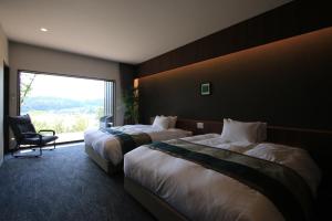 ein Hotelzimmer mit 2 Betten und einem Fenster in der Unterkunft 御宿 白金の森 in Kikuchi