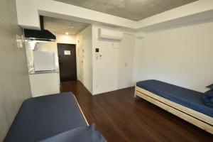 Habitación pequeña con cama y nevera. en Enzo iogi, en Tokio
