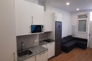 a kitchen with a black refrigerator and a couch at Nidito Enamorados in Pamplona