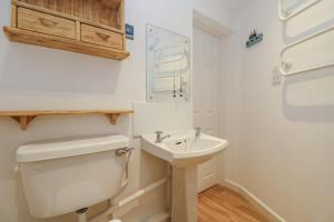 un baño con inodoro y lavabo en Cockle Island Cottage, en Porthallow 23 fotos más