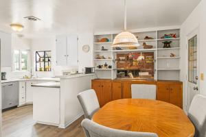 a kitchen with a wooden table and white cabinets at Colorful Gold Coast Getaway in Santa Barbara