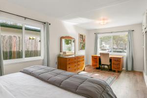 Colorful Gold Coast Getaway في سانتا باربرا: غرفة نوم بسرير ومكتب ومرآة