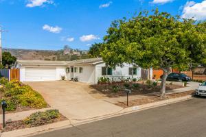 una casa blanca con un árbol y una entrada en Colorful Gold Coast Getaway en Santa Bárbara
