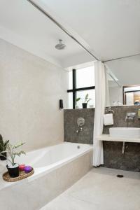 a bathroom with a bath tub and a sink at Monarch Luxur - Infantry Road in Bangalore