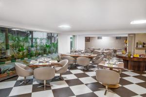 a restaurant with tables and chairs on a checkered floor at Monarch Luxur - Infantry Road in Bangalore