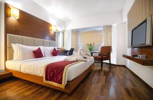 a hotel room with a bed and a television at Monarch Luxur - Infantry Road in Bengaluru +16 photos