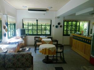 a restaurant with tables and chairs in a room at Rea Hotel in Palaiochora