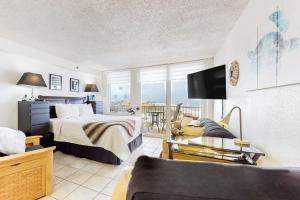 um quarto com uma cama, um sofá e uma televisão em Harbour Beach Resort Unit 518 em Daytona Beach
