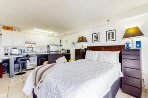 a bedroom with a large bed and a kitchen at Harbour Beach Resort Unit 518 in Daytona Beach