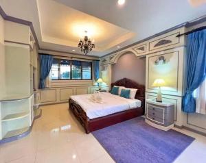 ein Schlafzimmer mit einem großen Bett und blauen Vorhängen in der Unterkunft 高尔夫泳池花园6卧高端别墅 in Ban Huai Yai